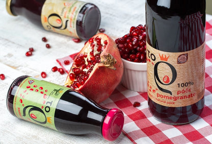 Granatapfel aufgeschnitten auf dem Tisch und eine Flasche Granatapfelsaft