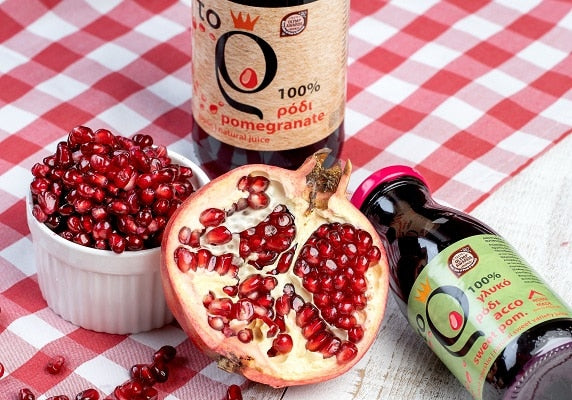 Granatapfel aufgeschnitten auf dem Tisch und eine Flasche Granatapfelsaft